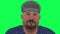 Talking colored eyed middle aged man in gray hat and blue shirt on green screen