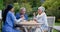 Talking, garden and a nurse with a couple for breakfast, conversation and coffee together. Happy, table and a female