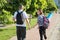 Talking middle-aged man and woman, couple walking along park road