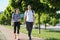 Talking middle-aged man and woman, couple walking along park road