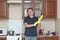 A tall adult man yellow rubber gloves in home clothes