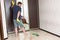 A tall adult man yellow rubber gloves is mopping floors