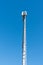 Tall antenna tower for mobile and cellular telephone service with a blue sky background