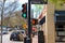 A tall black light post with a traffic light on the street on green and a pedestrian signal with a red hand