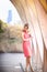 Tall blond woman standing in coral halter dress in front of The Pavillion near Lincoln Park Zoo in Chicago, Illinois.