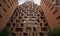 A tall brick building with lots of windows and brutalism zig zag hoog detail. AI generated