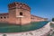 Tall brick walls of an old military fort on an island of Dry Tortugas. Florida. Blue sky, green water, beautiful summer