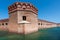 Tall brick walls of an old military fort on an island of Dry Tortugas. Florida. Blue sky, green water, beautiful summer