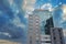 A tall building with glass elements against a blue sky