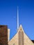 Tall church steeple and cross with blue sky background