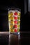 Tall colourfull glass filled with iced lemonade isolated on dark background