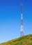Tall Communication Tower on a Hill With Blue Sky