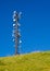 Tall Communication Tower on a Hill With Blue Sky