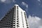 Tall condominium building under cloudy blue sky