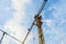 Tall construction crane against blue sky