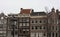 Tall Dutch buildings built in red bricks in the style of Amsterdam. cold autumn day, gray and cloudy