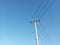 Tall Electricity Pole with Its Wires or Cables Against Clear Blue Sky Background