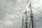 Tall elegant lines of ship masts against grey stormy skyline outside