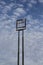 Tall empty highway sign frame against a blue sky with clouds, centered, copy space