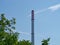 Tall factory chimney with a background of blue sky
