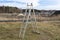 A tall, fold-out aluminum ladder standing in the yard, in the shape of a triangle.