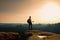 Tall ginger hair hiker in grey t-shirt and dark trekking trousers on cliff. Man with tourist poles in hand and sporty backpack