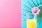 Tall Glass with Freshly Squeezed Pineapple Citrus Tropical Fruit Juice with Straw and Flower. Pink and Blue Background Palm Leaf