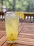 Tall glass of lemonade on teak patio table.