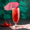 Tall glass of pink ginger ale and grenadine syrup with festive garnishes