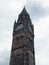 The tall gothic stone clock tower of rochdale town hall in lancashire against a blue cloudy sky