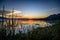 Tall grass at waters edge partially covers the horizon during sunset at Lake Chapala in Ajijic Mexico