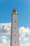 Tall gray lighthouse tower with red light