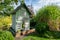 Tall green birdhouse on a tree hanging in garden