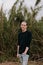 Tall and Handsome Young Man with Long Hair Pulled Back Modeling in Front of Very Tall Grass Outside in Nature