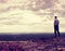 Tall hiker or sportsman on the cliff in rocky mountains park and watch down landscape