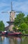 Tall historic Dutch windmill with boat in Gouda