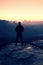 Tall man in black on cliff and watch to mountain sunrise.Silhouette in selfconfident pose