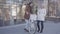 Tall man holding his bicycle talking with pretty blond woman in warm jacket. Positive couple chatting standing near the