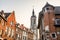 Tall medieval bell tower rising over the street with old european houses, Tournai, Walloon municipality, Belgium