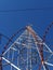 Tall mobile phone tower against  a blue, cloudless sky.