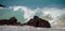 Tall morning wave breaks on rocks of Puako beach