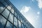 Tall multi-storey building with mirrored windows against the sky. Modern urban architecture.