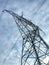 Tall North American hydro tower against cloudy blue sky.