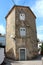 Tall old building with dilapidated cracked walls and closed metal window blinds on path crossing connected with multiple