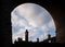 Tall old chimney pots tops under railway bridge arches on homes and houses below red brick train arch silhouetted on summer day