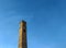 Tall Ottoman Turkish style architecture building old clock tower in Sarajevo with blue sky in background and plane leaving trail