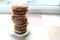 Tall pile of used teabags on a teabag shaped plate, on a kitchen windowsill