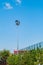 Tall pillar with spotlights to illuminate a football stadium against the sky with clouds and protective mesh