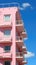 A tall pink building with balconies and balconies on the balconies. Generative AI image.