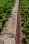 Tall red brick retaining wall with rusticated stone cap